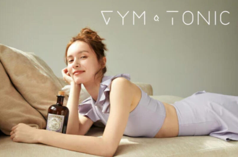 Gym and Tonic A girl in gymwear holding a bottle of gin in bed.